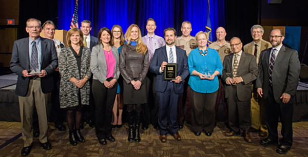 Group of 15 people holding Toward Zero Deaths awards.